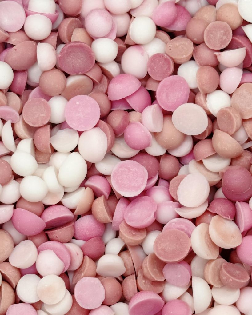 A close up view of pink and white wax melt scoopie drops for use in a wax melt burner