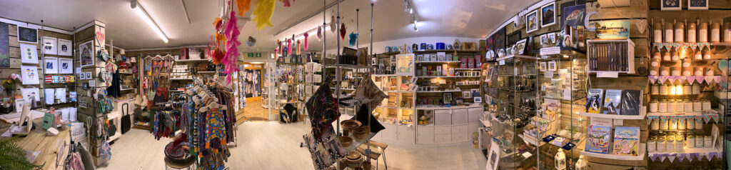 A panoramic photograph of the interior of the shop.  wooden clad shop full of handmade crafts and gifts.